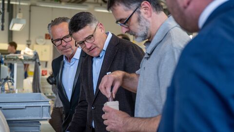 Ministerpräsident Boris Rhein und Prof. Bernd Kracke lassen sich die Arbeit in der Höchster Porzellanmanufaktur zeigen.