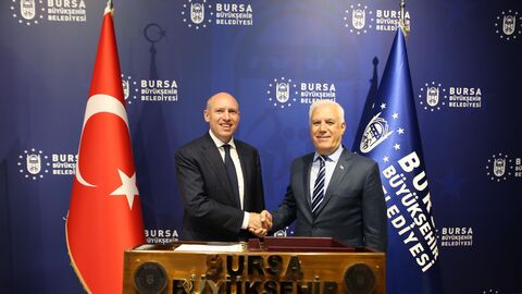 Europaminister Pentz schüttelt Hand von Bürgermeister von Bursa. Im Hintergrund befinden sich die Flaggen der Türkei und der Region Bursa