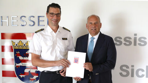 Innenminister Roman Poseck ernennt Felix Paschek zum neuen Landespolizeipräsidenten Innenminister Roman Poseck steht Felix Paschek und überreicht ihm eine Urkunde
