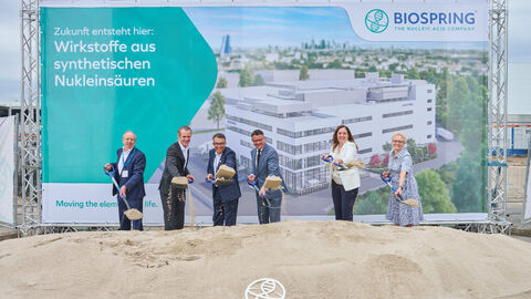 v.l.n.r. Paul-Gerhard Weiß (Stadtrat Offenbach), Dr. Felix Schwenke (Oberbürgermeister Offenbach), Dr. Hüseyin Aygün (CSO BioSpring), Boris Rhein (Ministerpräsident Hessen), Dr. Sylvia Wojczewski (CEO BioSpring), Sabine Groß (Bürgermeisterin Offenbach) Sechs Personen stehen nebeneinander vor einem Sandhaufen. Sie schütten gerade mit der Schaufel Sand auf den Haufen.
