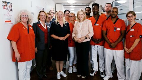 Bundesgesundheitsministerin Nina Warken und die Hessische Gesundheitsministerin Diana Stolz beim Rundgang mit Einrichtungs- und Pflegedienstleitung, Gabriele Roettger und Stefanie Wingenfeld, sowie den Mitarbeitenden des Hauses Dietrichsroth in Dreieich. Bundesgesundheitsministerin Nina Warken und Gesundheitsministerin Diana Stolz mit Pflegekräften stehen in einer Reihe.